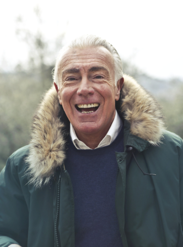 Senior man smiling outside in front of mountains