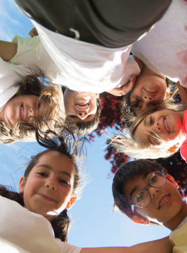 Kids smiling standing in a big circle